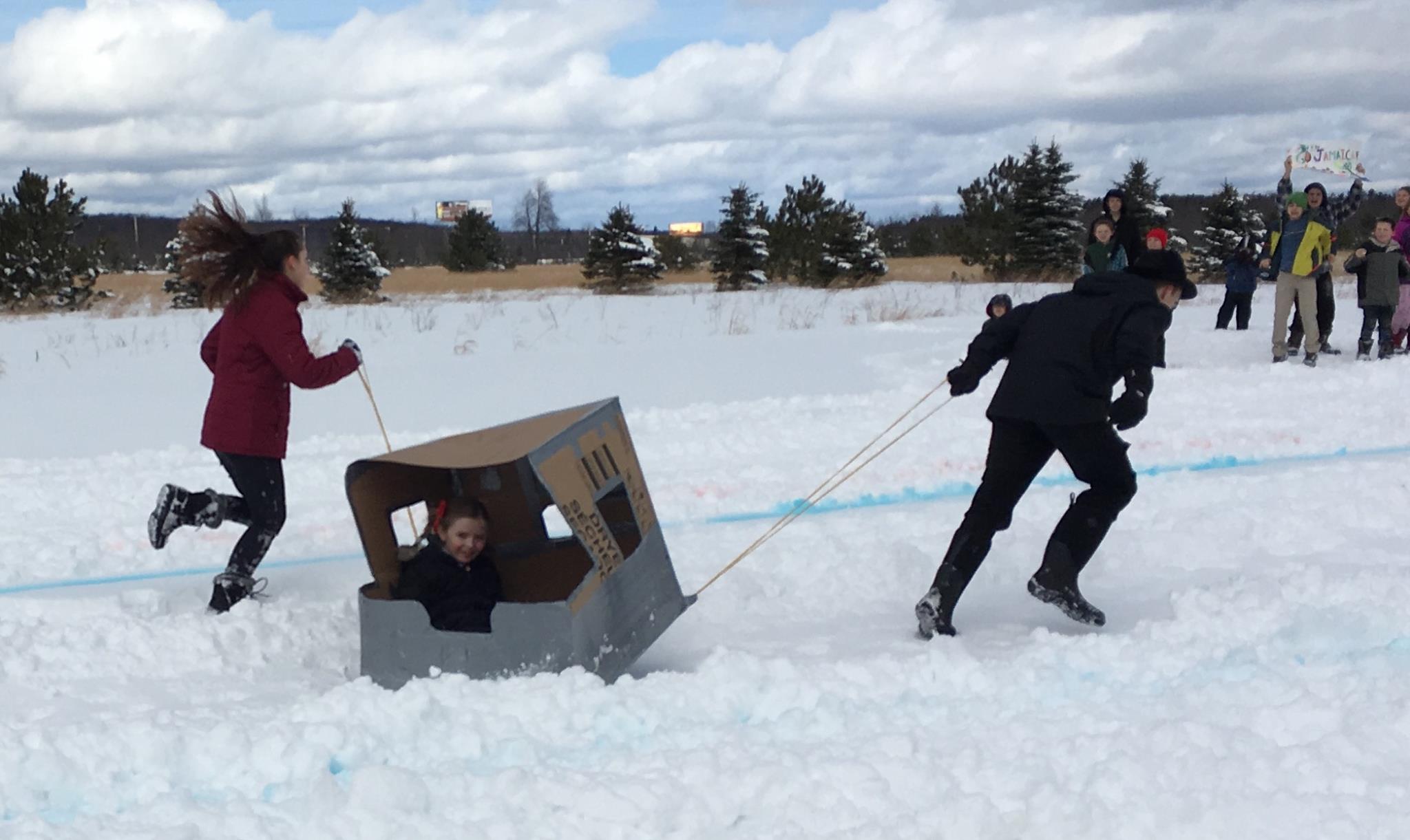 Students participating in a cardboard sled race.